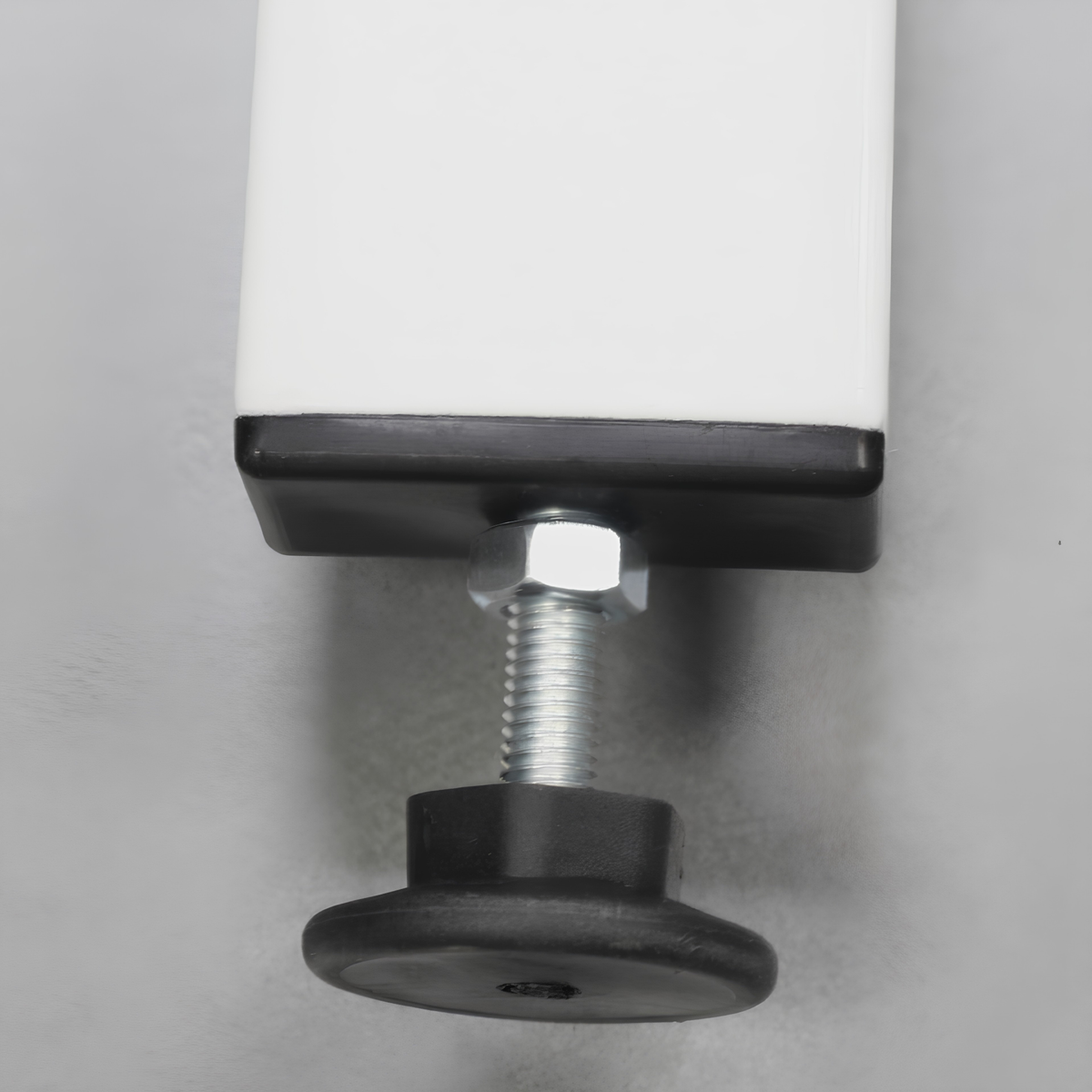 Close-up of a white rectangular furniture leg with a black base, adjustable silver metal threaded bolt, and round black rubber feet on a gray background.