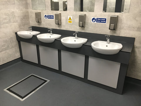 Four-basin vanity unit with a black worktop and light grey access panels, installed for Eddie Stobart