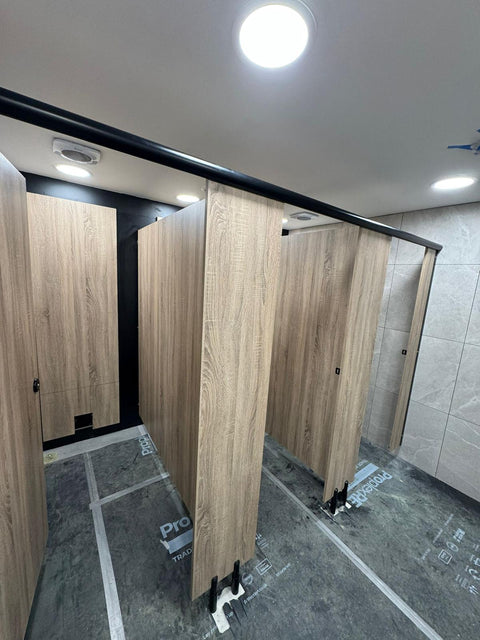 Ascent Range woodgrain toilet cubicles and IPS panelling during installation, the floor still protected