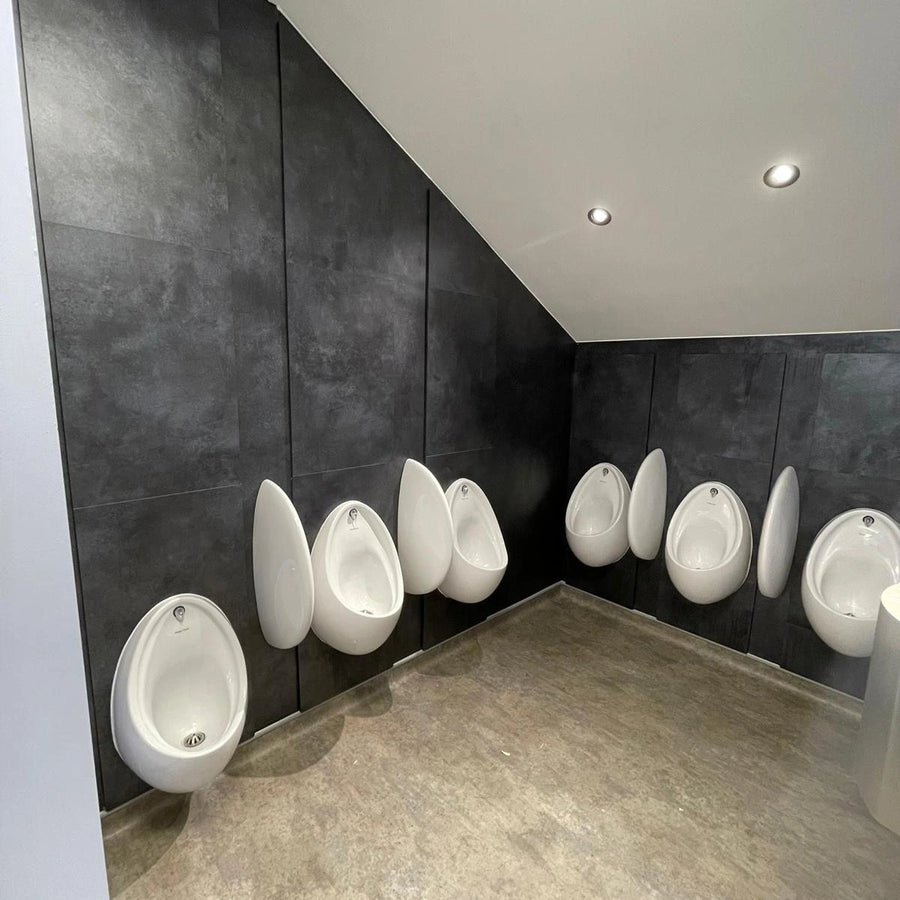 Grey IPS panels behind a run of urinals