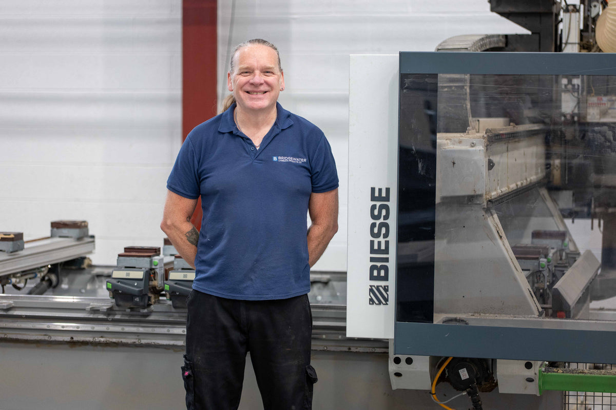 Bridgewater Direct CNC operator standing beside a Biesse machining centre in the Bolton workshop