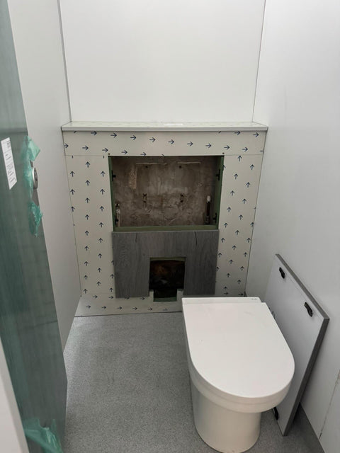 Half-height IPS behind a WC during installation, the access panel off to show the cistern and the frame still in protective film