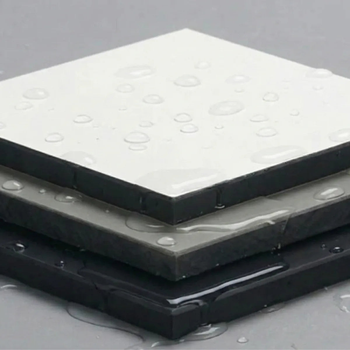 Water droplets beading on laboratory compact laminate, showing its waterproof solid core