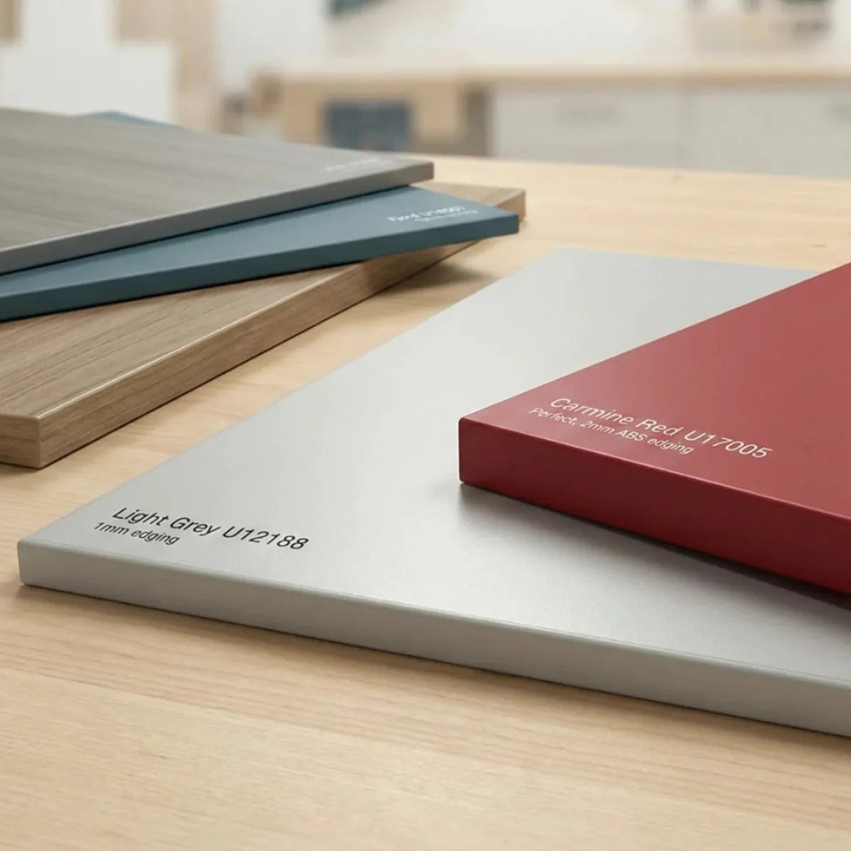 Stacked 18mm MFC panel samples in various colours including Light Grey and Carmine Red, showing the high-quality melamine finish and professional edged borders.