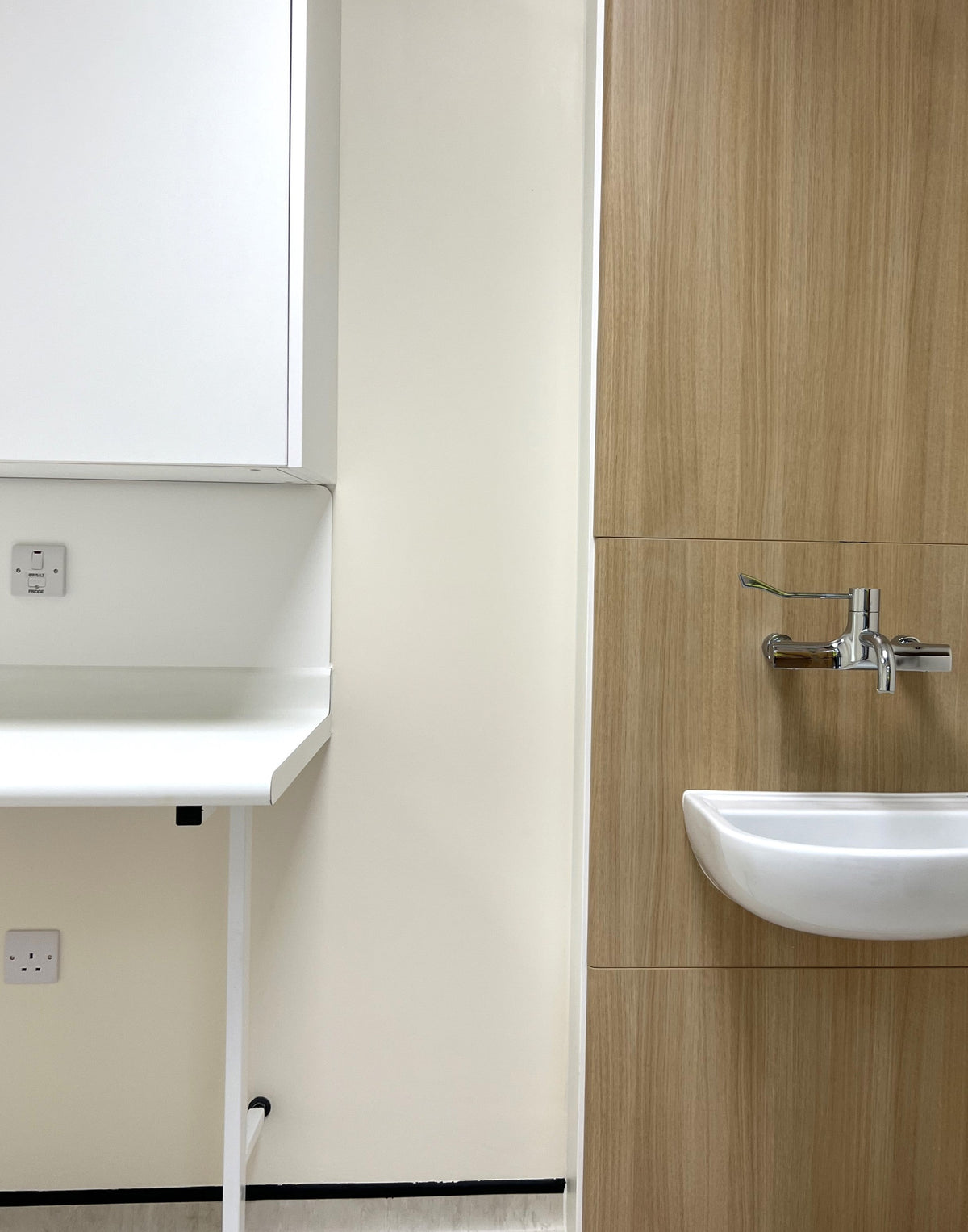Laminate worktop with integral coved upstand installed beside a clinical wash hand basin