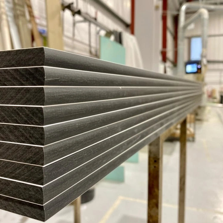 White compact grade laminate panels in the workshop with CNC-machined slightly rounded edges and a solid black core
