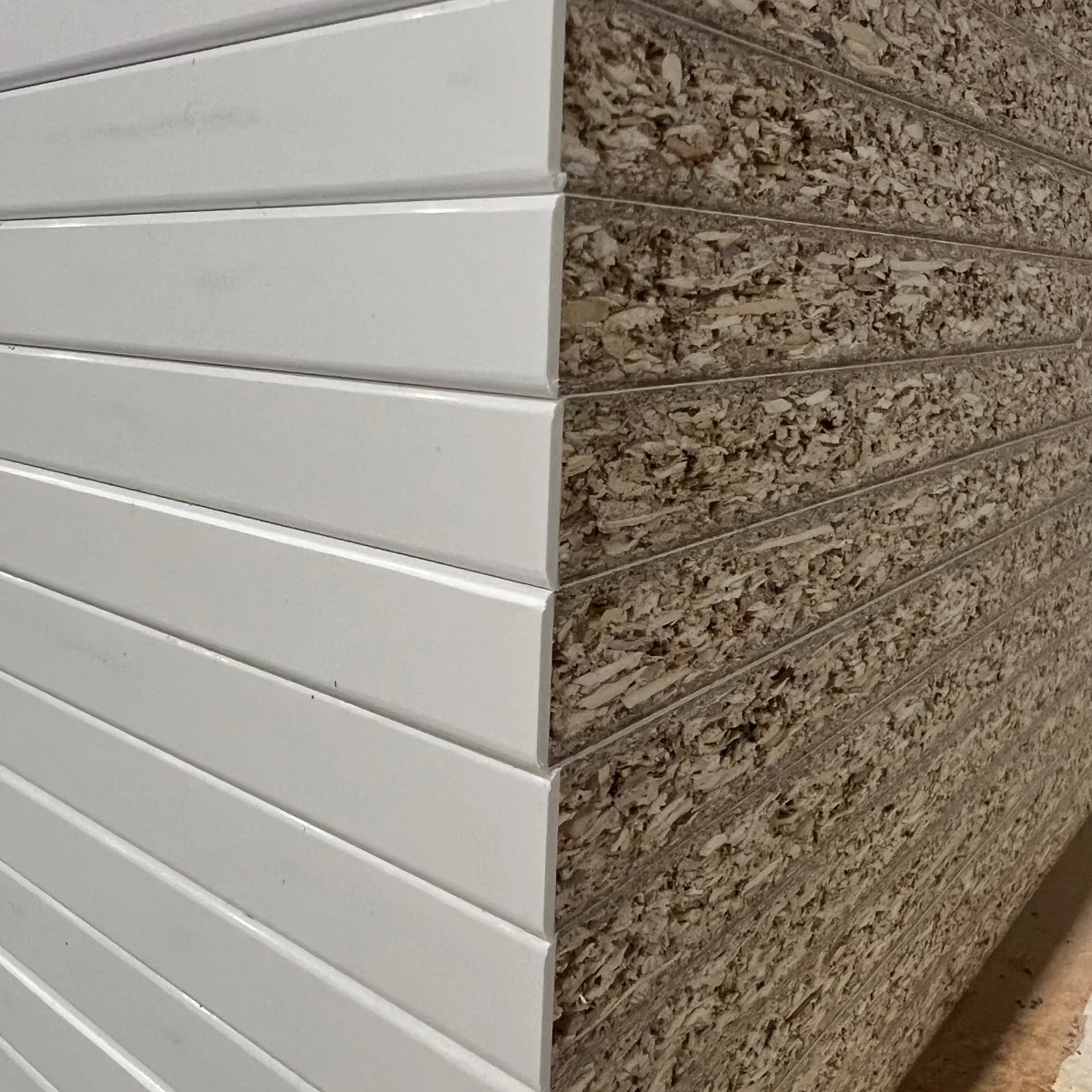 Close-up comparison of raw chipboard edge and white PVC edge banding on MFC panels
