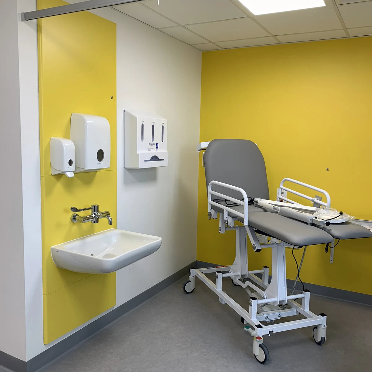 Postformed IPS wall panels installed in a healthcare WC, featuring seamless rounded edges around a sink and clinical fixtures.