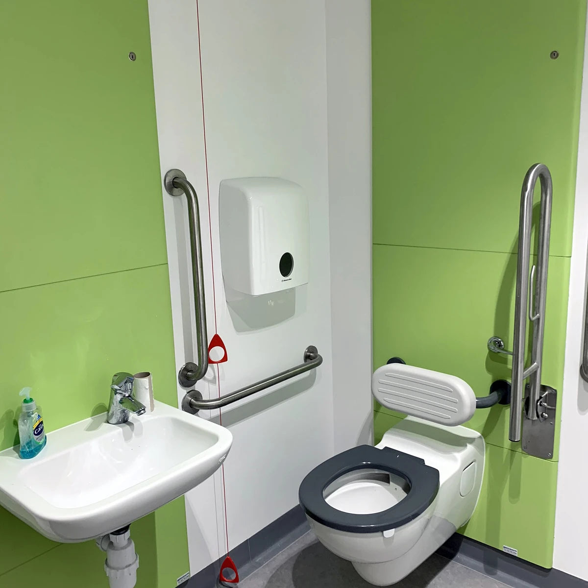 Postformed WC wall panels with seamless rounded edges installed in an accessible washroom.